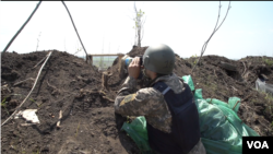 Gjatë pauzave ndërmjet bombardimeve, ushtarët ukrainas në llogore vëzhgojnë për lëvizjet e forcave ruse (Kamianske, Ukrainë)