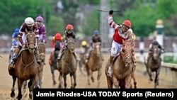 May 7, 2022; Louisville, KY, USA; Sonny Leon aboard Rich Strike celebrates winning the 148th running of the Kentucky Derby at Churchill Downs. 