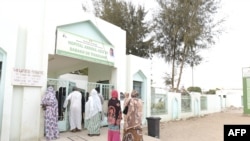 Des visiteurs se tiennent devant l'hôpital Mame Abdoul Aziz Sy Dabakh, où onze bébés sont morts à la suite d'un incendie électrique présumé, à Tivaouane, au Sénégal, le 26 mai 2022.