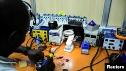 Joel Ssematimba, a hardware developer at a low-cost air quality monitoring dubbed AirQo, works on air quality monitoring devices inside a workshop at the Makerere University in Kampala, Uganda, May 27, 2022.