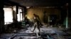 A Ukrainian serviceman inspects a school damaged during a battle between Russian and Ukrainian forces in the village of Vilkhivka, on the outskirts of Kharkiv, in eastern Ukraine, May 20, 2022. 