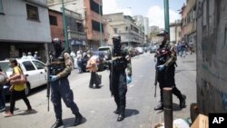 Agentes de las fuerzas especiales conminan a la gente a quedarse en sus casas durante el periodo de pandemia de COVID=19 en Caracas, el 30 de marzo de 2020.