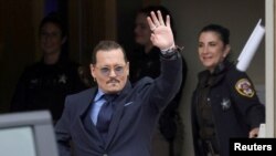 El actor Johnny Depp hace un gesto al salir del juzgado de circuito del condado de Fairfax luego de su juicio por difamación contra su ex esposa Amber Heard, en Fairfax, Virginia, EE. UU., el 27 de mayo de 2022.