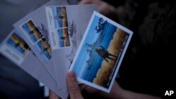 A man holds stamps printed by Ukraine's state postal service celebrating the defiance to sunken Russian flagship Moskva in Kyiv, Ukraine, May 23, 2022. The flagship of Russia's Black Sea Fleet sank in April 2022 during the Russian invasion of Ukraine.