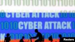 FILE: Figurines with computers and smartphones are seen in front of the words "Cyber Attack", binary codes and the Russian flag, in this illustration taken Feb. 15, 2022. 