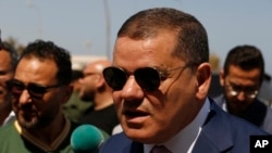 Abdul Hamid Dbeibah, one of Libya’s two rival prime ministers, speaks to residents as he visits a Tripoli neighborhood after competing militias fought there, in Tripoli, Libya, May 17, 2022.