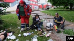 Paramedics and emergency workers provide medical care to the wounded as a result of shelling in Kharkiv, Ukraine, May 26, 2022.