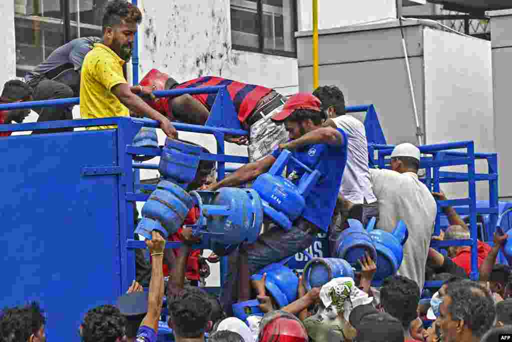 Enraged crowd who had been waiting in line overnight for supplies loot a truck transporting cooking gas cylinders in Colombo, Sri Lanka.