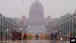 FILE - A construction worker walks across a road during a heat wave, in New Delhi, May 2, 2022. (AP Photo/Manish Swarup)