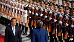 FILE - Chinese Premier Li Keqiang, left, and Solomon Islands Prime Minister Manasseh Sogavare review an honor guard during a welcome ceremony at the Great Hall of the People in Beijing, on Oct. 9, 2019.