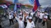 Cambodia's Candlelight Party supporters wave before marching during an election campaign for the June 5 communal elections in Phnom Penh, Cambodia, Saturday, May 21, 2022. (AP Photo/Heng Sinith)