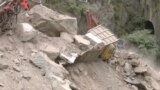 Foto dari tangkapan layar menunjukkan sebuah alat berat memindahkan puing-puing di sekitar kendaraan yang terjebak setelah runtuhnya terowongan yang sedang dibangun di Ramban, Jammu, dan Kashmir, Jumat, 20 Mei 2022. (Foto: ANI via Reuters)