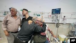 Un periodista herido es abrazado por uno de los colegas de la periodista Shireen Abu Akleh, reportera de la cadena Al Jazeera que murió baleada, en el Hospital de Cisjordania en Yenín, el miércoles 11 de mayo de 2022. (AP Foto/Majdi Mohammed)