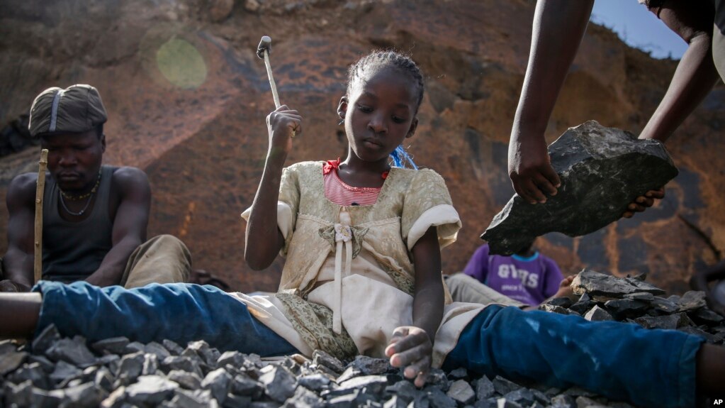 FILE - Irene Wanzila, 10, works breaking rocks with a hammer at the Kayole quarry in Nairobi, Kenya, Sept. 29, 2020, along with her younger brother, older sister and mother.