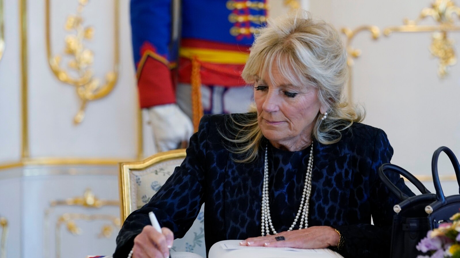 FILE - First lady Jill Biden signs a guest book during her visit with President of Slovakia Zuzana Caputova at the Presidential Palace in Bratislava, Slovakia, May 9, 2022. 