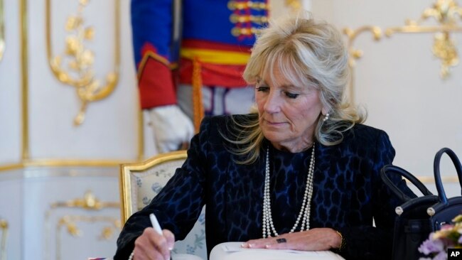 FILE - First lady Jill Biden signs a guest book during her visit with President of Slovakia Zuzana Caputova at the Presidential Palace in Bratislava, Slovakia, May 9, 2022.