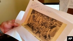 FILE - Adjunct history professor and research associate Larry Larrichio holds a copy of a late 19th century photo of students at an Indigenous boarding school in Santa Fe, during an interview in Albuquerque, New Mexico, July 8, 2021.