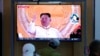 People watch a TV screen showing a news program reporting about North Korea's missile launch with file footage of North Korean leader Kim Jong Un at a train station in Seoul, South Korea, May 12, 2022.
