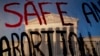 The Supreme Court is seen through a banner reading "Safe Abortion" in Washington on May 10, 2022. 
