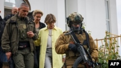 French Foreign Minister Catherine Colonn, center, visits the site of a mass grave in the Ukrainian town of Bucha, near Kyiv on May 30, 2022.