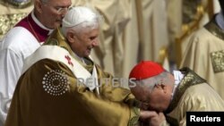ARCHIVO - El secretario de Estado del Vaticano, el cardenal Angelo Sodano (derecha), besa el anillo del papa Benedicto mientras dirige su misa inaugural en la Plaza de San Pedro en el Vaticano el 24 de abril de 2005.