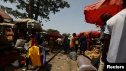 FILE - People trade along a railway line passing through a market in Kaduna, Nigeria, April 30, 2021.