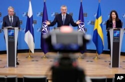 FILE - NATO Secretary General Jens Stoltenberg, center, speaks at a media conference with Finland's Foreign Minister Pekka Haavisto, left, and Sweden's Foreign Minister Ann Linde, at NATO headquarters in Brussels, Belgium Jan. 24, 2022.