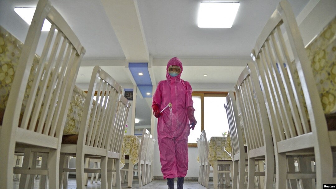 Seorang petugas tampak menyemprotkan cairan disinfektan ke dalam ruang makan di sebuah pabrik di tengah perebakan COVID-19, di Pyongyang, Korea Utara, pada 16 Mei 2022. (Foto: Kyodo via Reuters)
