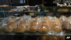 A customer looks at display cases in a bakery in Tehran, Iran, May 11, 2022. Iran abruptly raised prices as much as 300% for a variety of staples Thursday. 