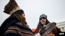 Dos mujeres escuchan a oradores durante la Marcha de los Pueblos Indígenas en el en el Lincoln Memorial, en la Explanada Nacional, en Washington DC, el 18 de enero de 2019. 