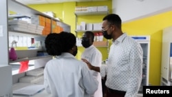 Dr. Yaw Bediako (R) CEO of Yemaachi Biotechnology, speaks with scientists at the cancer research laboratory in Accra, Ghana May 19, 2022.