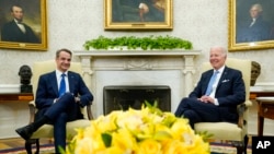 President Joe Biden, right, and Greek Prime Minister Kyriakos Mitsotakis meet in the Oval Office of the White House in Washington, May 16, 2022. 