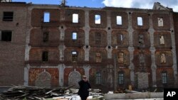 A woman called Albina, reacts in front of the destroyed Peter Dick's mill that had been damaged in Russian shelling in the village of Niu-York, Donetsk region, Ukraine, May 16, 2022. Photo: Associated Press