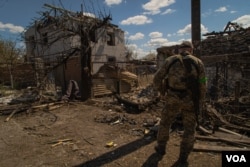 Soldiers examine a residential neighborhood shortly after a blast injured three in Zaporizhzhya, Ukraine, April 28, 2022. (Yan Boechat/VOA)