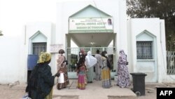 Des visiteurs se tiennent devant l'hôpital Mame Abdoul Aziz Sy Dabakh, où onze bébés sont morts suite à une panne électrique, à Tivaouane, le 26 mai 2022. (Photo SEYLLOU / AFP)