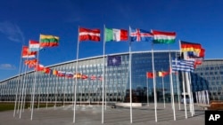 FILE - A NATO flag and flags of member countries flutter in the wind outside NATO headquarters in Brussels, Feb. 7, 2022. 