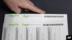 An election worker at the Clackamas County Elections Office shows examples of good and troublesome barcodes on ballots, May 19, 2022, Oregon City, Ore. Ballots with blurry barcodes that can't be read by vote-counting machines will delay election results by weeks in a key U.S. House race in Oregon's primary.