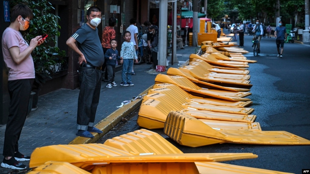 上海市民站在刚刚被推倒的用于封城的围栏旁。（2022年5月31日）(photo:VOA)