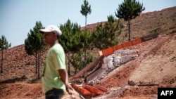 资料照：2016 年 10 月 7 日，一名男子站在一台采矿机旁，该采矿机正在过滤中国公司九星在马达加斯加索马哈马尼纳的矿山内的含金泥土。（法新社）