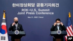 Presiden AS Joe Biden (kiri) dan Presiden Korea Selatan Yoon Suk Yeol mengenakan kembali masker pada akhir konferensi pers di Seoul, Korea Selatan, Sabtu, 21 Mei 2022. (Foto: Evan Vucci/Associated Prfess)