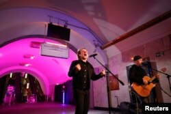 Bono and the Edge sing during a performance for Ukrainian people inside a subway station in Kyiv, Ukraine, as Russia's attack on Ukraine continues, May 8, 2022.