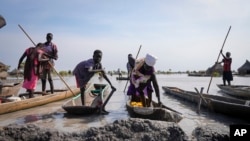 FILE - Residents park their dugout canoes next to a mud dyke they built to try and prevent flooding, in New Fangak town in Jonglei state, South Sudan on Dec. 25, 2021.