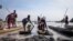 FILE - Residents park their dugout canoes next to a mud dyke they built to try and prevent flooding, in New Fangak town in Jonglei state, South Sudan on Dec. 25, 2021.