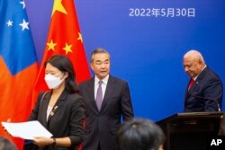 中国国务委员兼外长王毅与斐济总理巴依尼马拉马（右）在斐济出席太平洋岛国外长会议。（2022年5月30日）