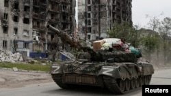 A Russian tank drives through the streets in the town of Popasna in the Luhansk Region, Ukraine, May 26, 2022. (REUTERS/Alexander Ermochenko)