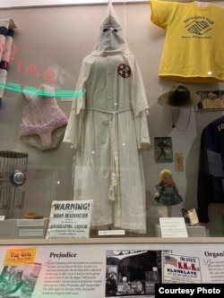Display of KKK robe among other artifacts in the South Dakota Cultural Heritage Museum in Pierre, S.D.