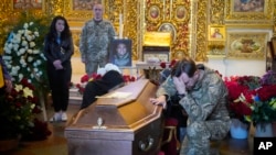 A soldier pays tribute to volunteer soldier and Ukrainian journalist Oleksandr Makhov, 36, killed by Russian troops, at St Michael cathedral in Kyiv, Ukraine, May 9, 2022. 