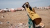 FILE - A woman carries a water container at a camp for internally displaced persons (IDPs) in Baidoa, Somalia, Feb. 13, 2022.