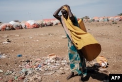 FILE - A woman carries a water container at a camp for internally displaced persons (IDPs) in Baidoa, Somalia, Feb. 13, 2022.