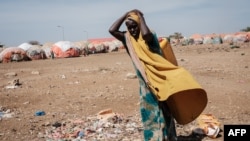 FILE - A woman carries a water container at a camp for internally displaced persons (IDPs) in Baidoa, Somalia, Feb. 13, 2022.